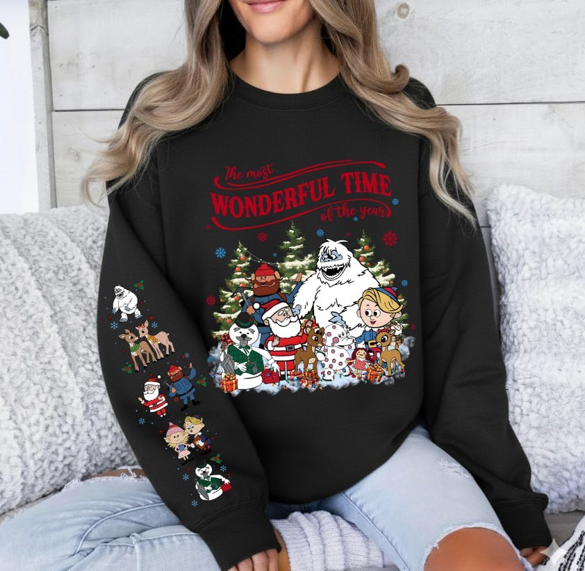Beige retro Rudolph The Red-Nosed Reindeer Christmas hoodie with sleeve prints, featuring Bumble, Santa, and "The most wonderful time of the year" quote