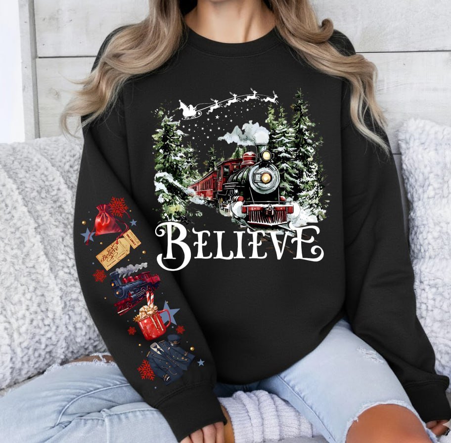 Black Christmas sweatshirt featuring a vintage train in a snowy forest with the word Believe, and Polar Express themed sleeve prints like a golden ticket and hot cocoa