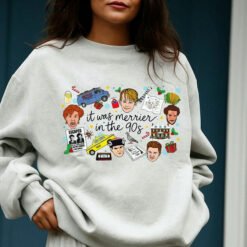 White crewneck Christmas sweatshirt featuring a retro 90s holiday movie collage design with the text "it was merrier in the 90s" alongside nostalgic characters and icons