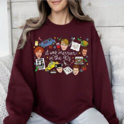 White crewneck Christmas sweatshirt featuring a retro 90s holiday movie collage design with the text "it was merrier in the 90s" alongside nostalgic characters and icons